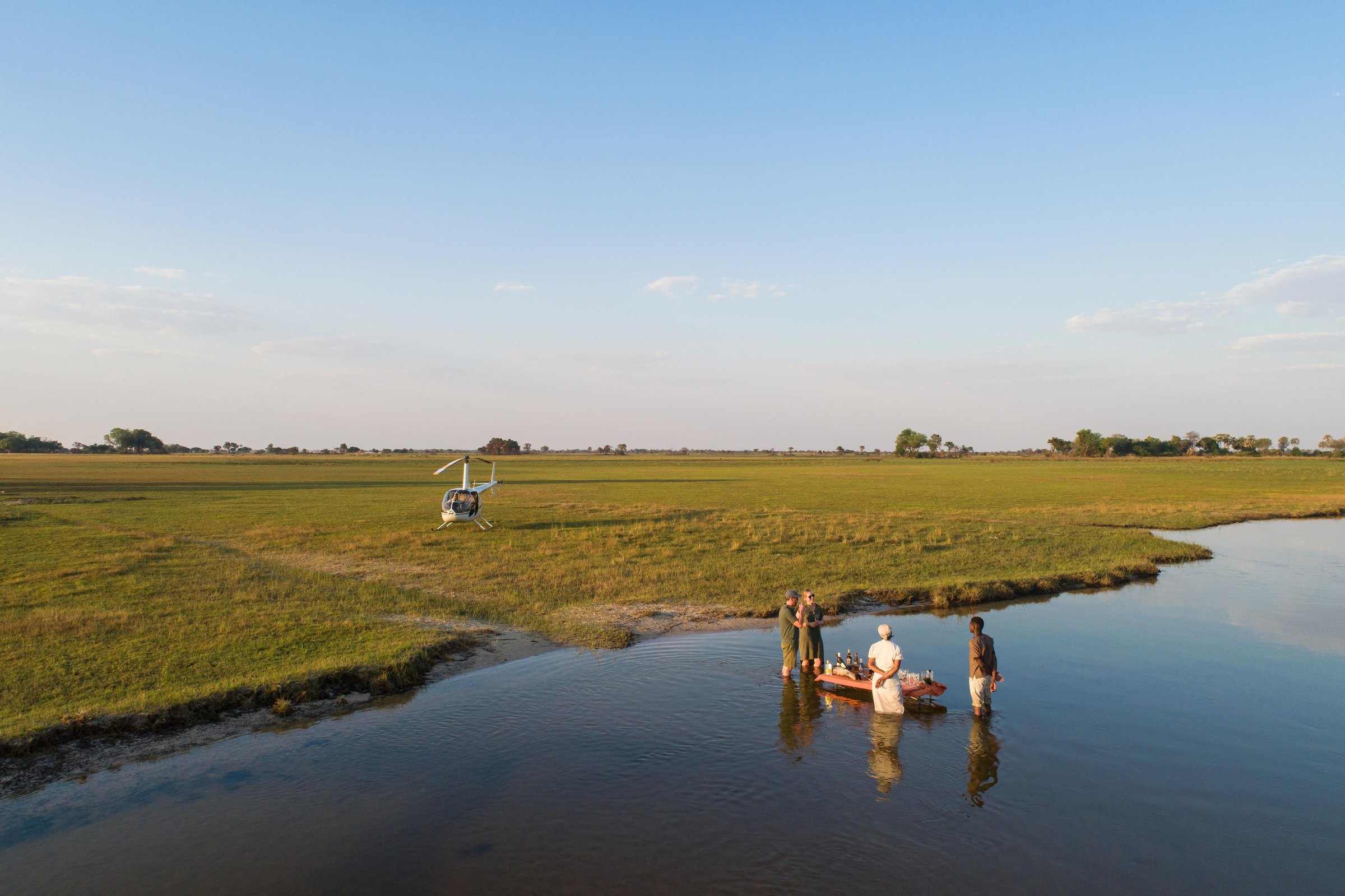 Helicopter and curated setup on Botswana salt pans at dusk