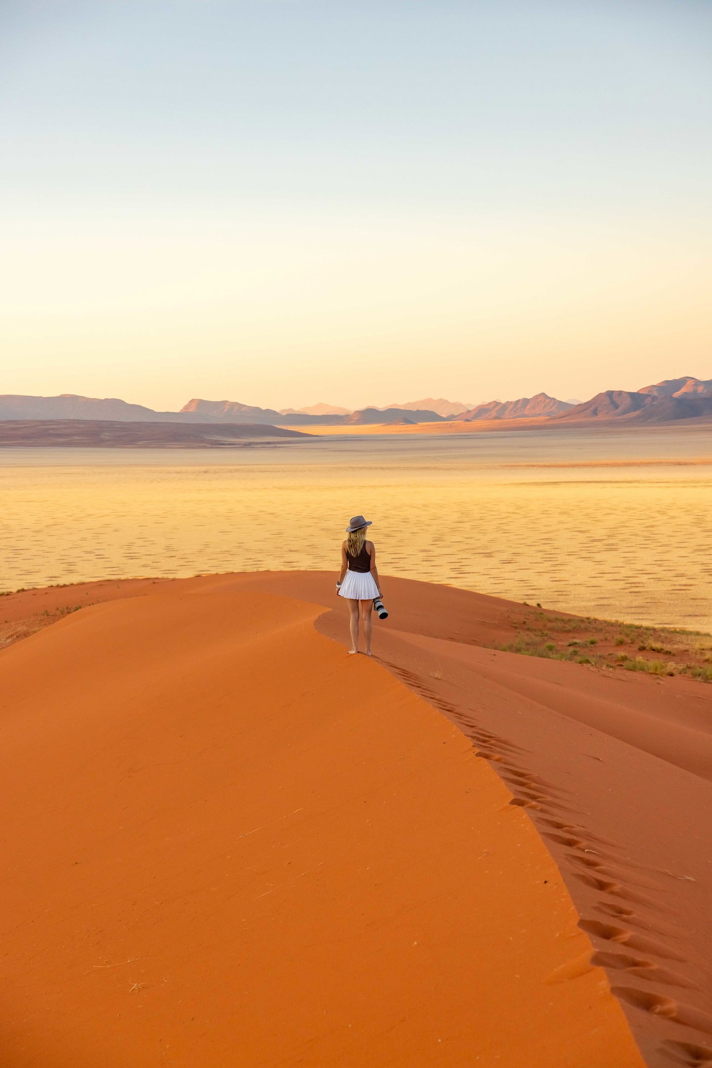 Traveller holding a camera on a red dune in Namibia