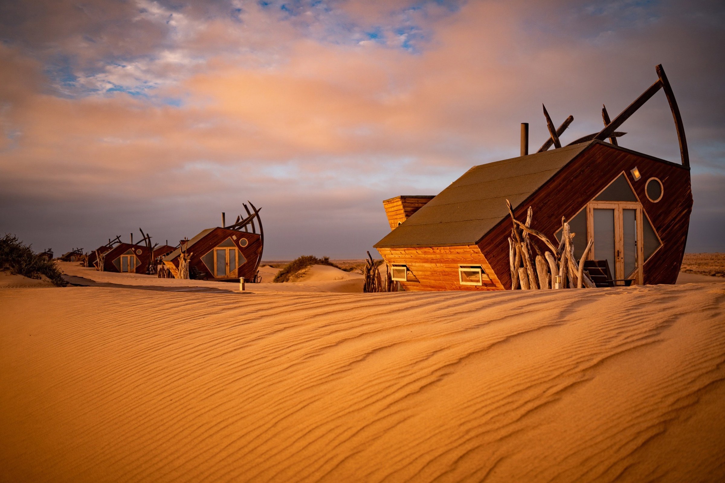 Ship-inspired wooden lodge buildings among dunes on Namibia’s Skeleton Coast