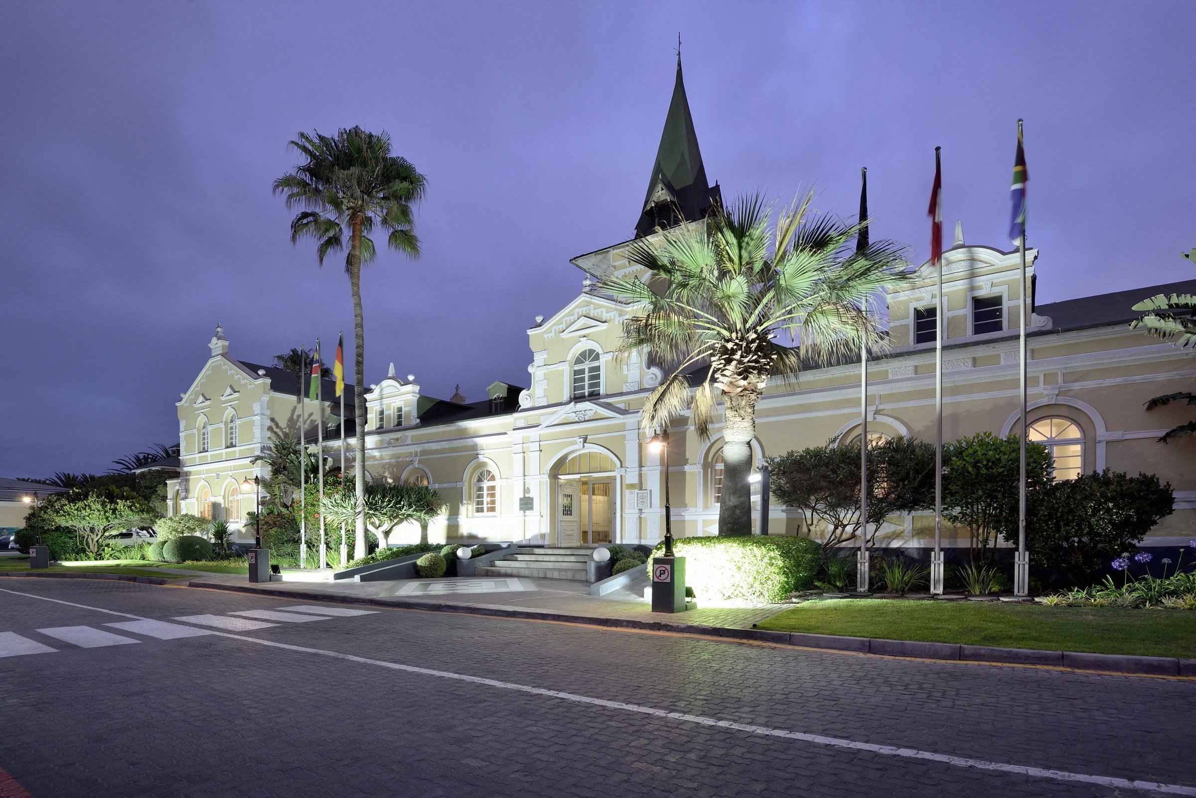 Historic building and palm trees illuminated at dusk in Swakopmund