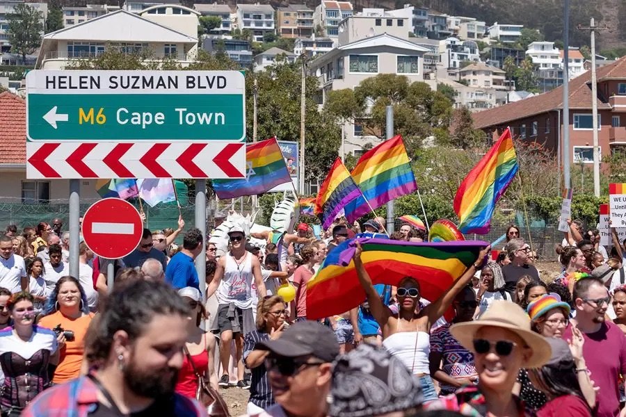 A crowd carrying rainbow flags at Cape Town Pride.
