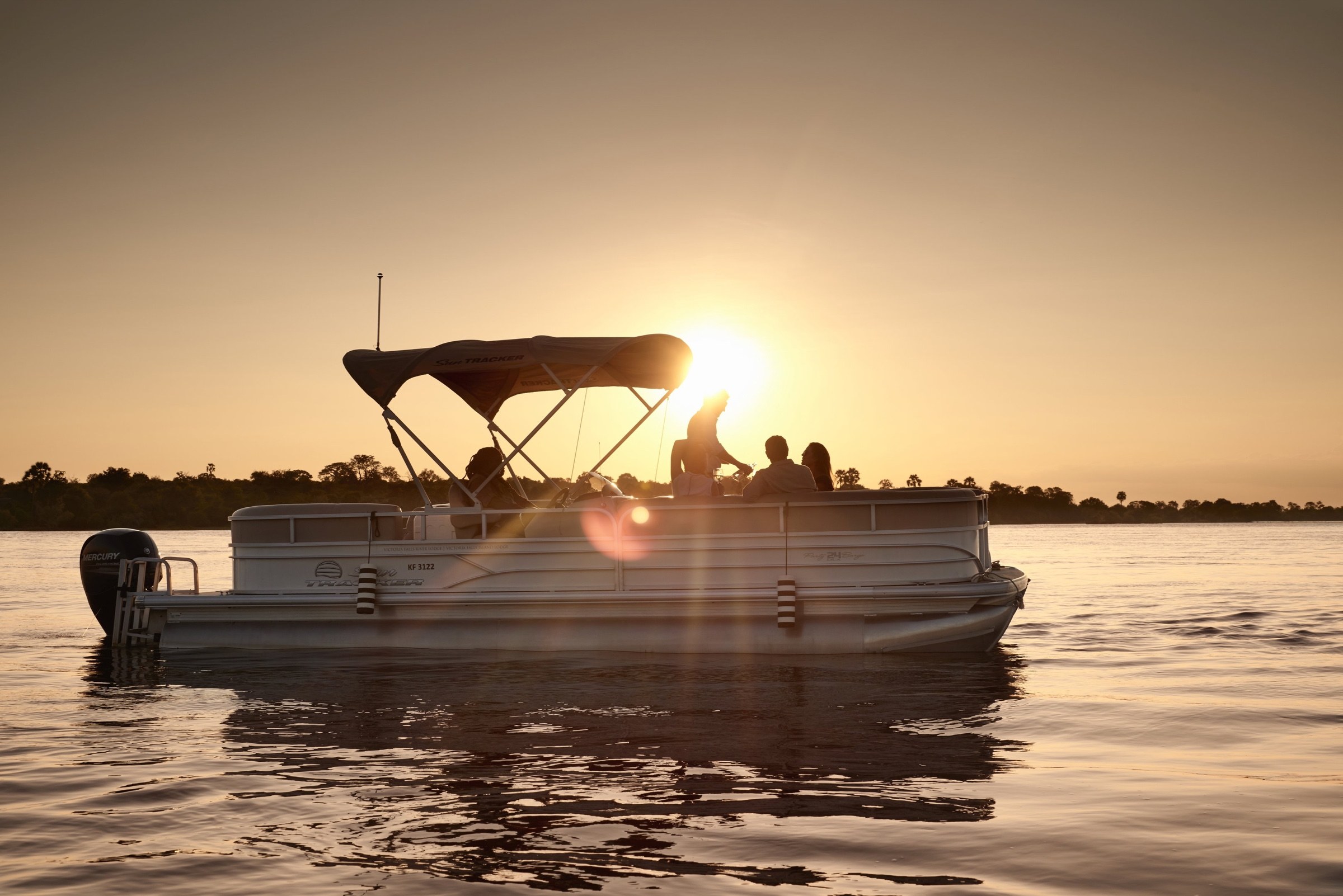 Boat carrying guests on the Zambezi River at sunset
