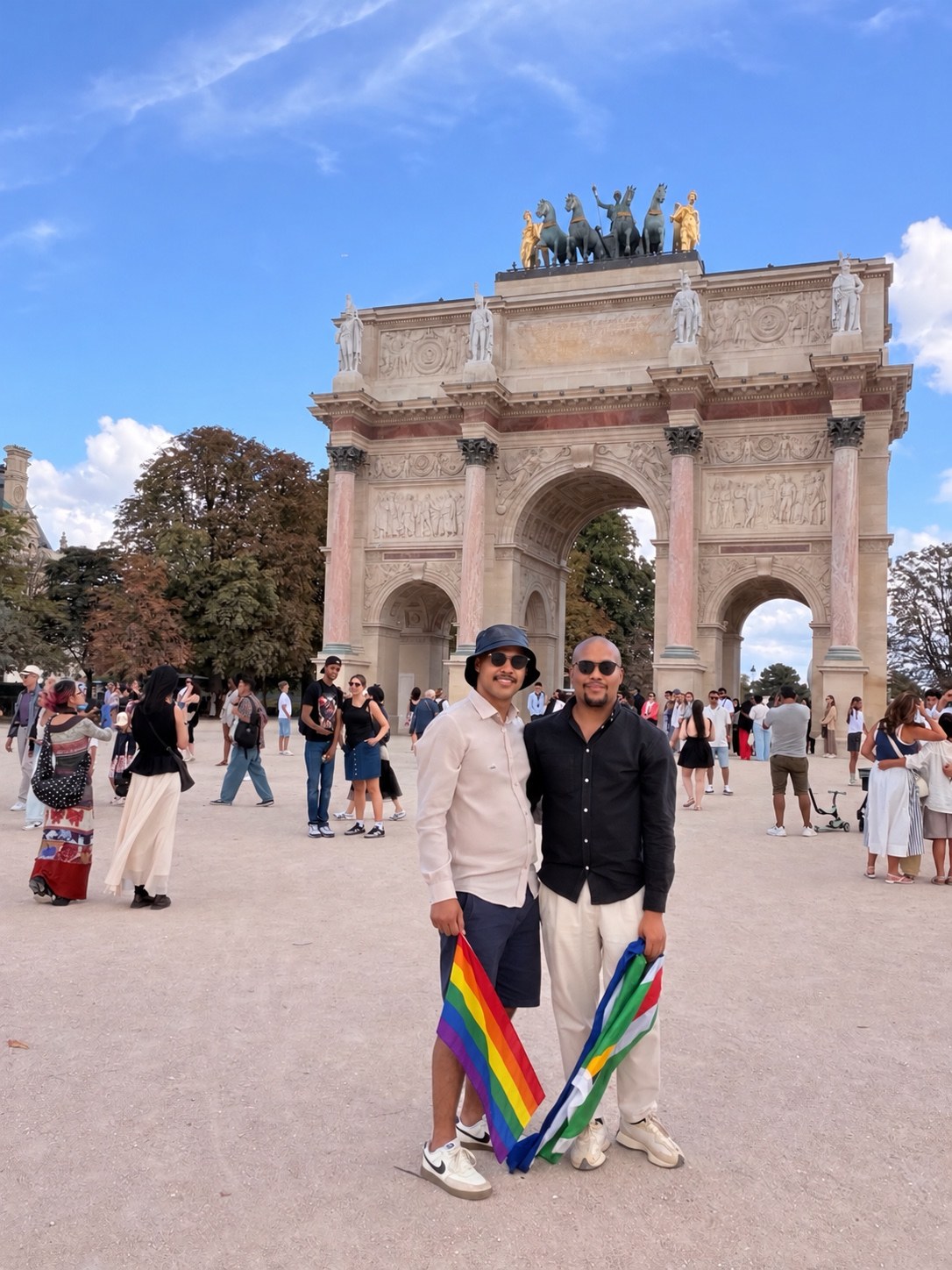 Zannon James and his partner Brandon in Paris holding Pride and South African flags