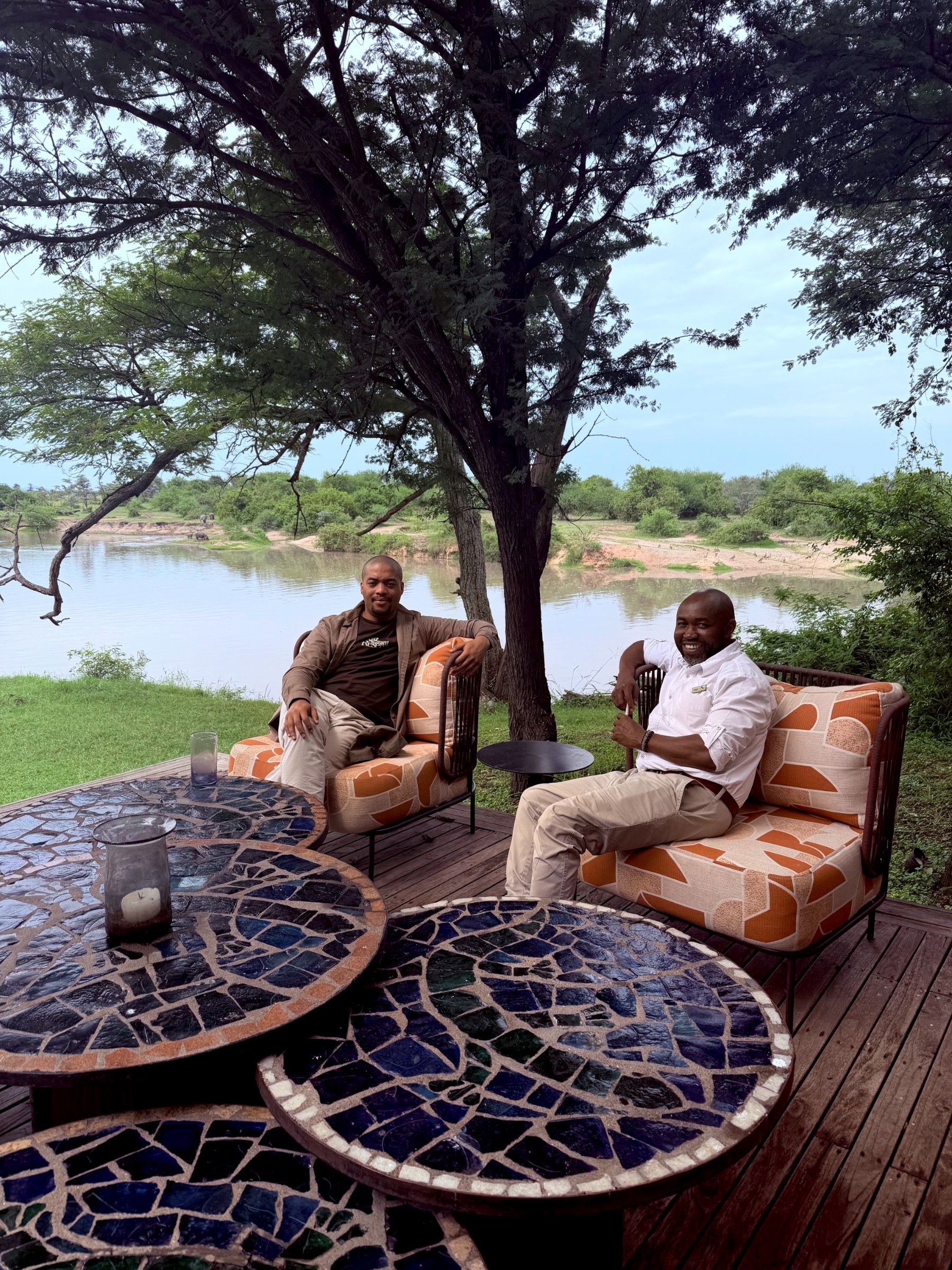 Zannon James with the &Beyond Grumeti lodge manager seated beside the water