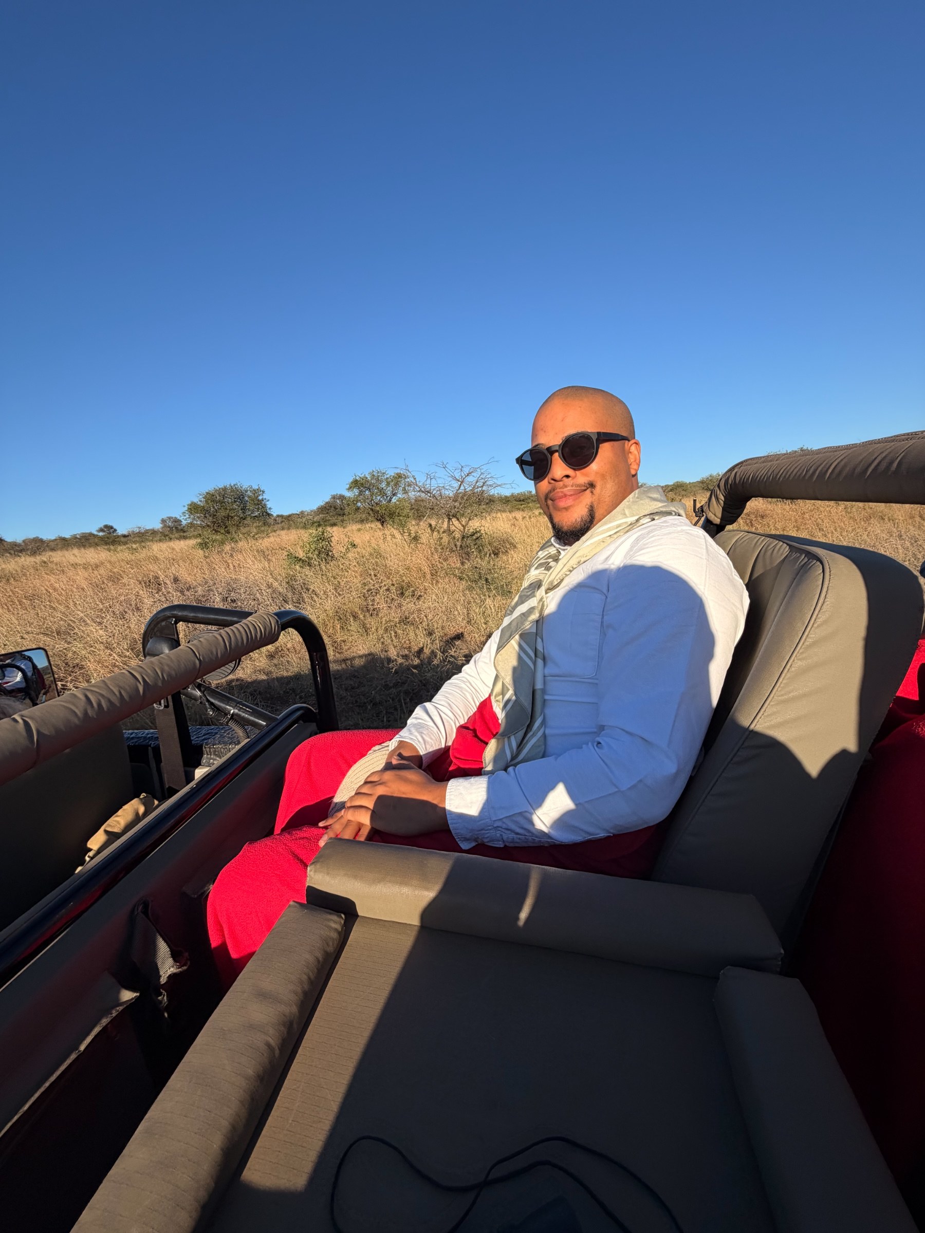 Zannon James seated in an open safari vehicle in Tanzania