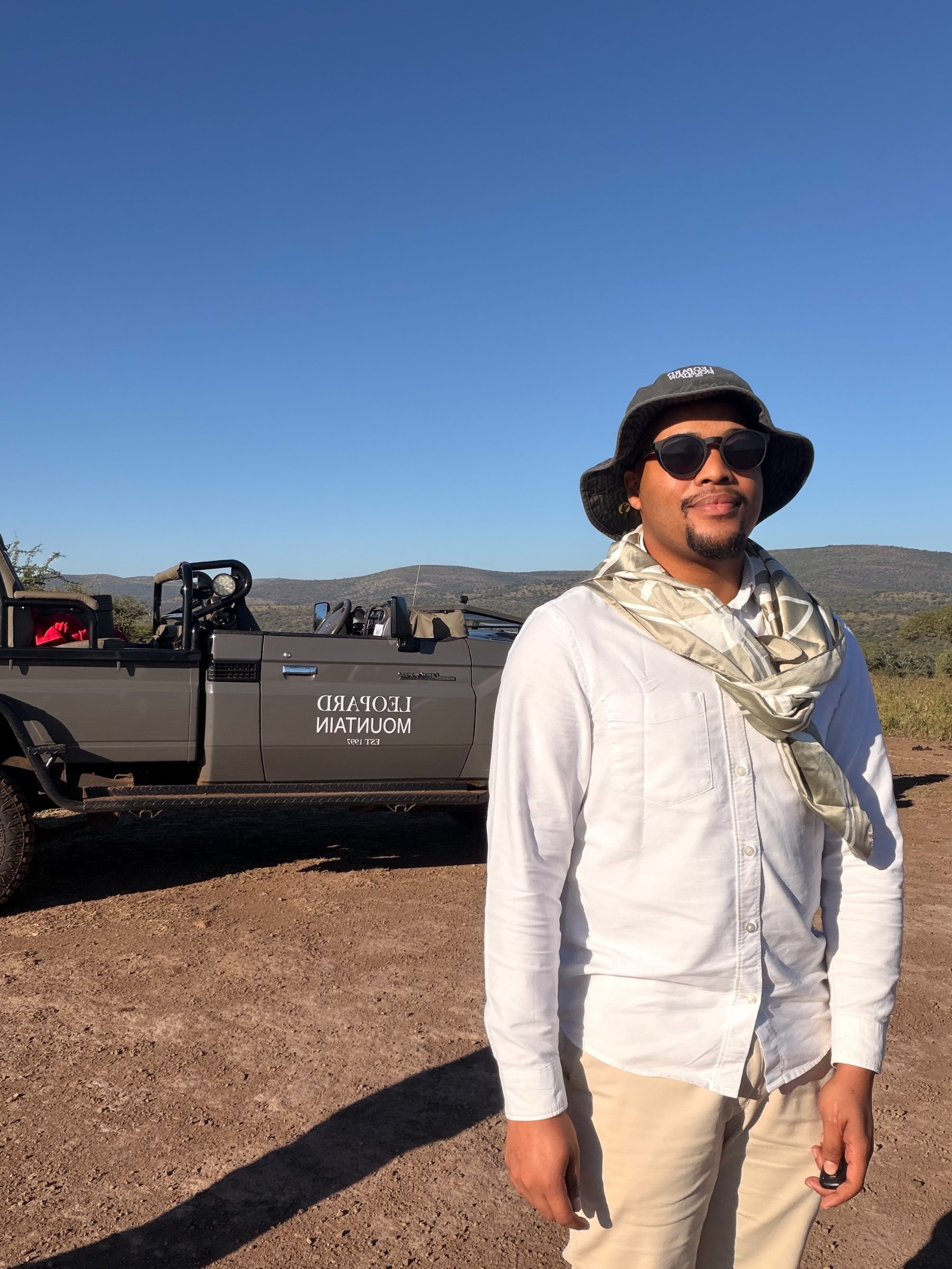 African travel specialist Zannon James beside a safari vehicle in Africa