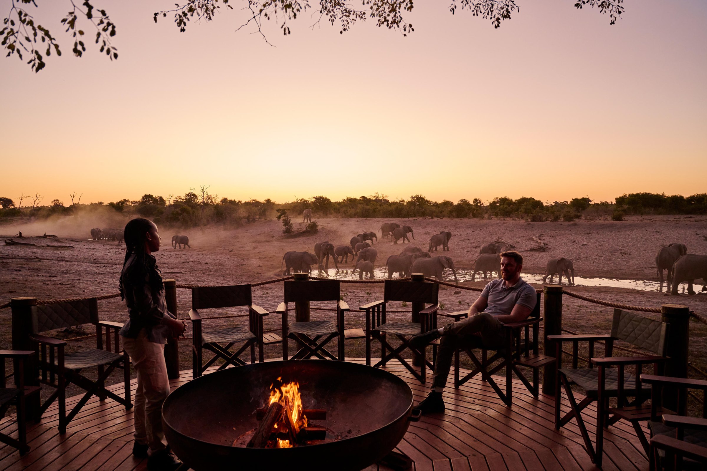 Savute safari lodge firepit at dusk with elephants at a distant waterhole