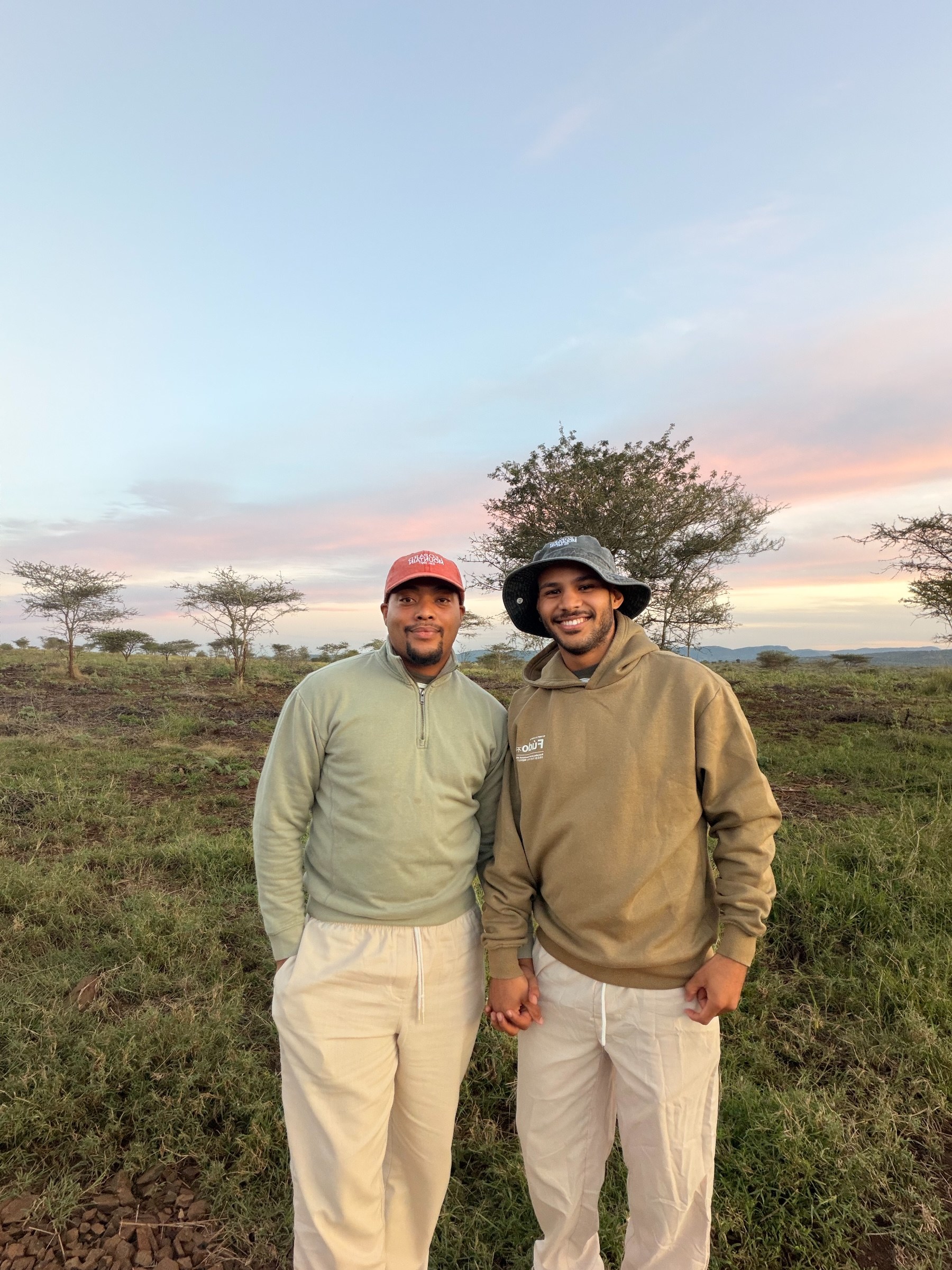 Zannon James and Brandon holding hands together in the African bush at sunset