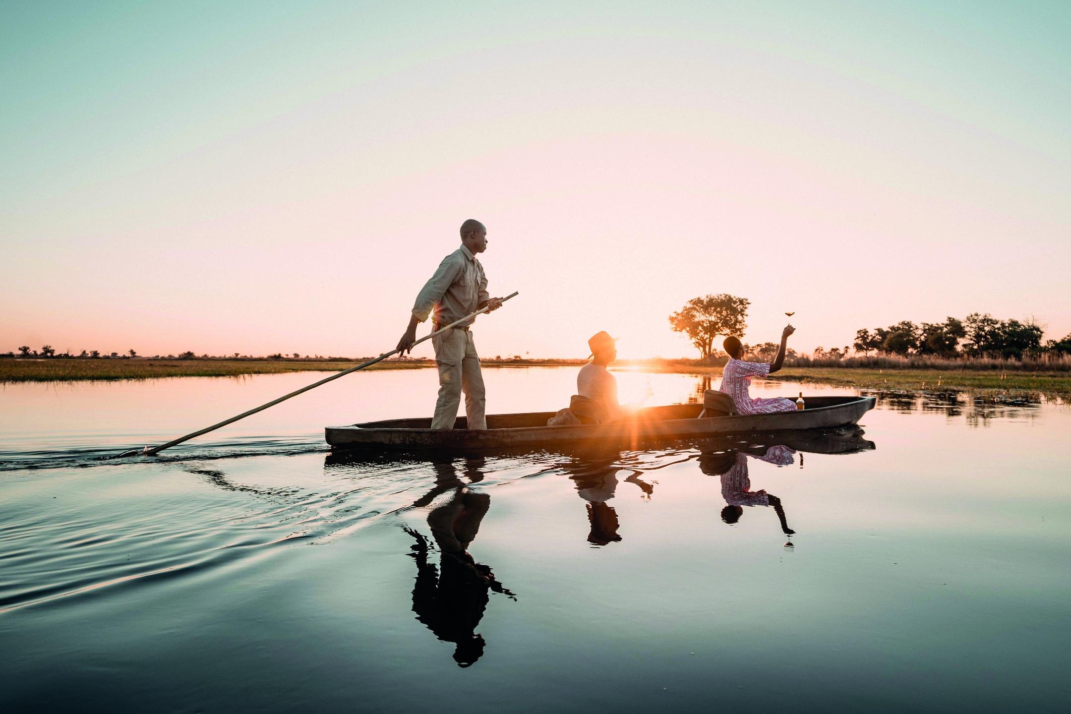Botswana mokoro gliding across the water at sunset