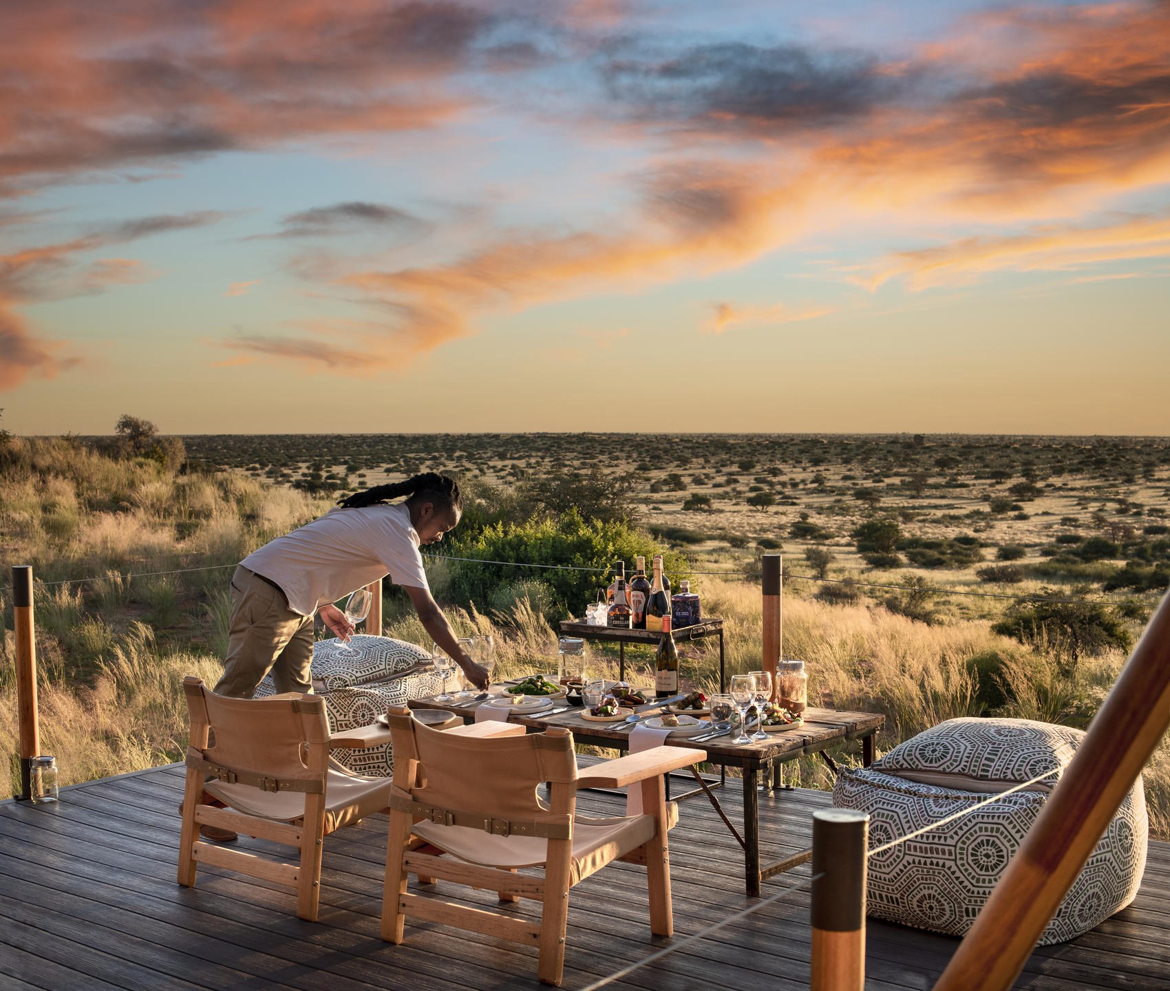 Lantern-lit lodge deck overlooking the Southern African landscape at dusk